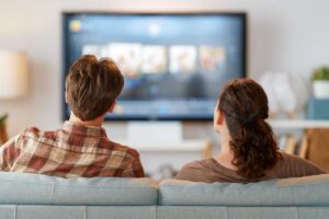 Due persone sedute sul divano che guardano la tv