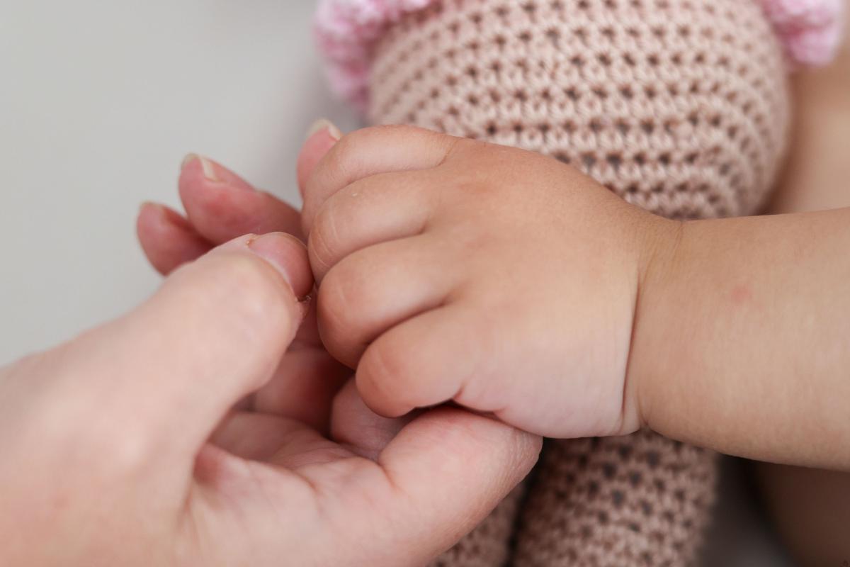 Madre tiene la mano di una neonata