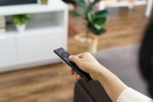 Telecomando in mano ad una persona che cambia canale