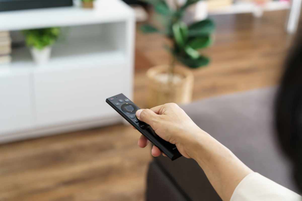 Telecomando in mano ad una persona che cambia canale